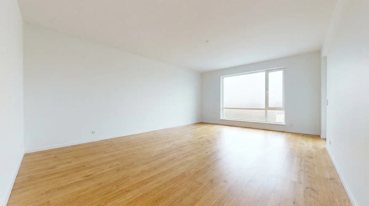Empty unfurnished living room with light oak floor and white walls before styling