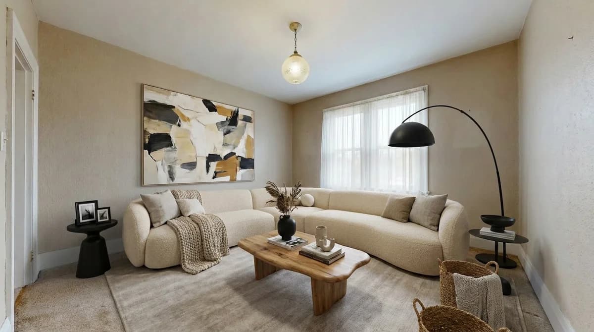 The same room furnished in a contemporary style with a curved boucle sofa, abstract art, and matte black accents
