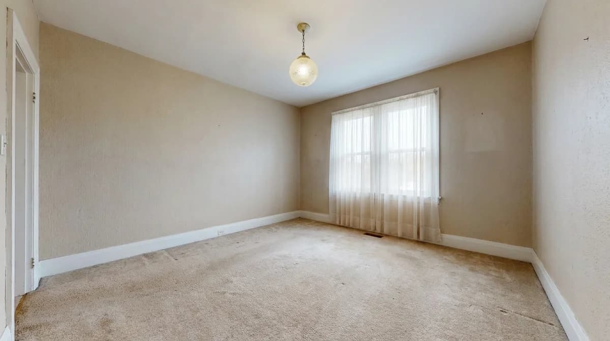 Empty unfurnished living room with beige walls and a large window before design