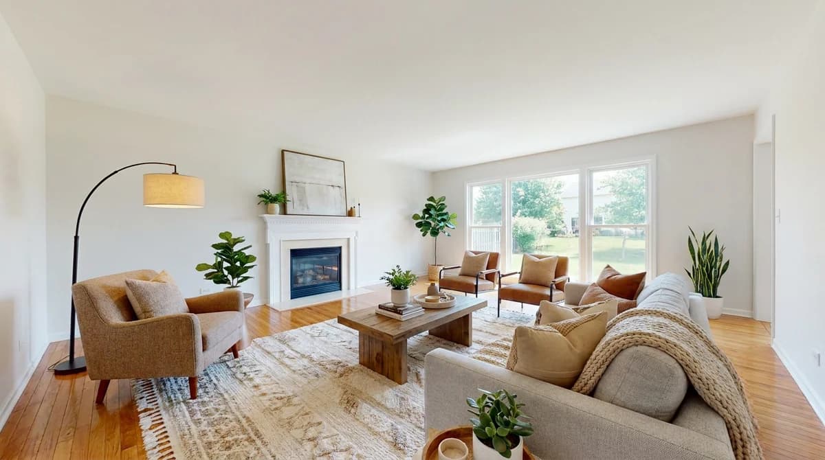 The same living room after AI virtual staging with a sofa, chairs, rug, and art